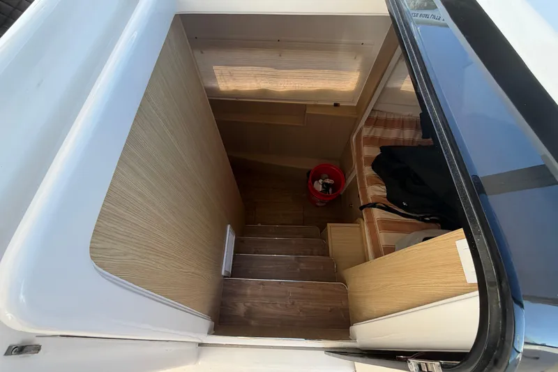 Chasin' Hyde Yacht Photos Pics Interior view of 2023 Aquila 36 Sport boat cabin with wooden stairs and seating area.