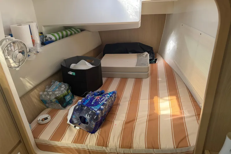 Chasin' Hyde Yacht Photos Pics Interior cabin of 2023 Aquila 36 Sport with striped bedding and supplies.