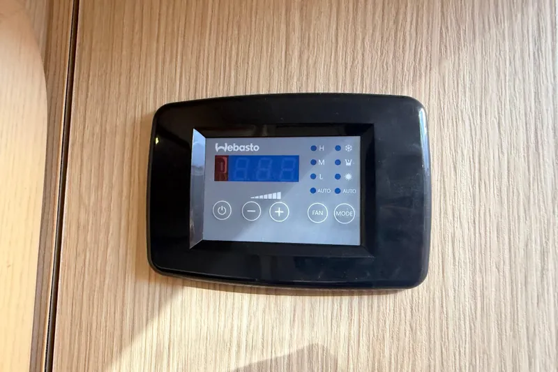 Chasin' Hyde Yacht Photos Pics Digital control panel on 2023 Aquila 36 Sport boat, mounted on wooden surface.