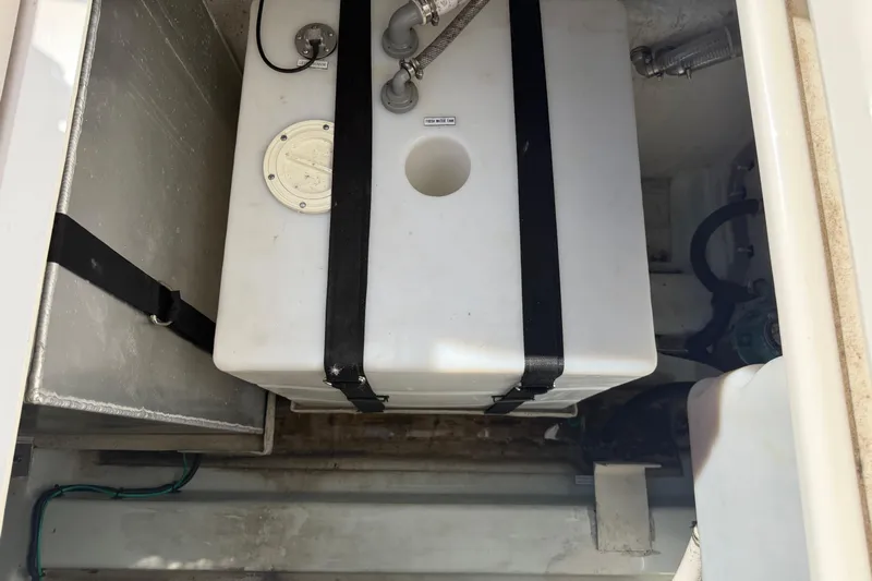 Chasin' Hyde Yacht Photos Pics 2023 Aquila 36 Sport boat storage compartment with secured white tank.