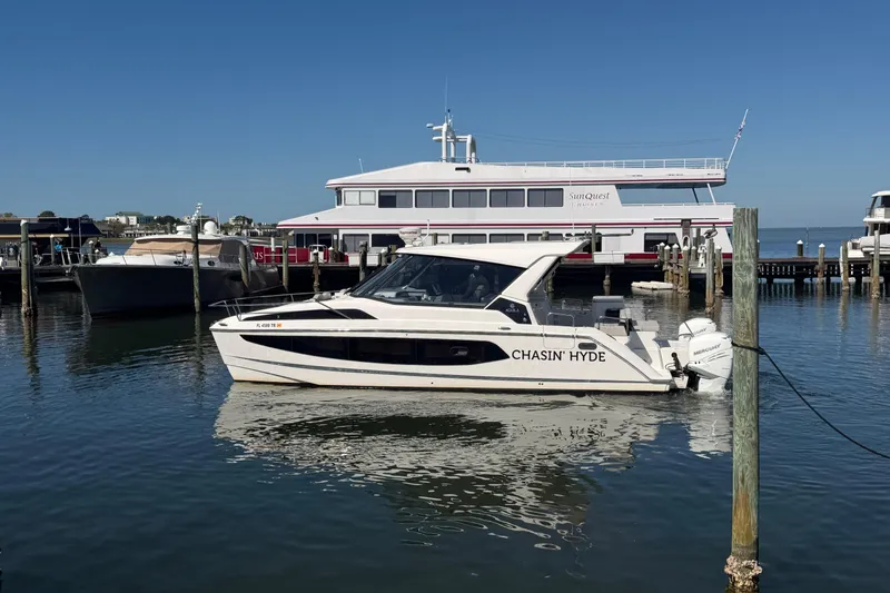 Chasin' Hyde Yacht Photos Pics 2023 Aquila 36 Sport boat docked in marina, clear blue sky background.
