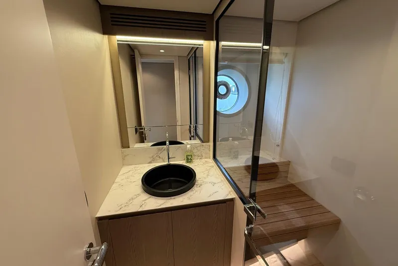 Dolce Far Niente Yacht Photos Pics Luxurious bathroom in 2024 Azimut Magellano 60 yacht with modern fixtures and porthole window.
