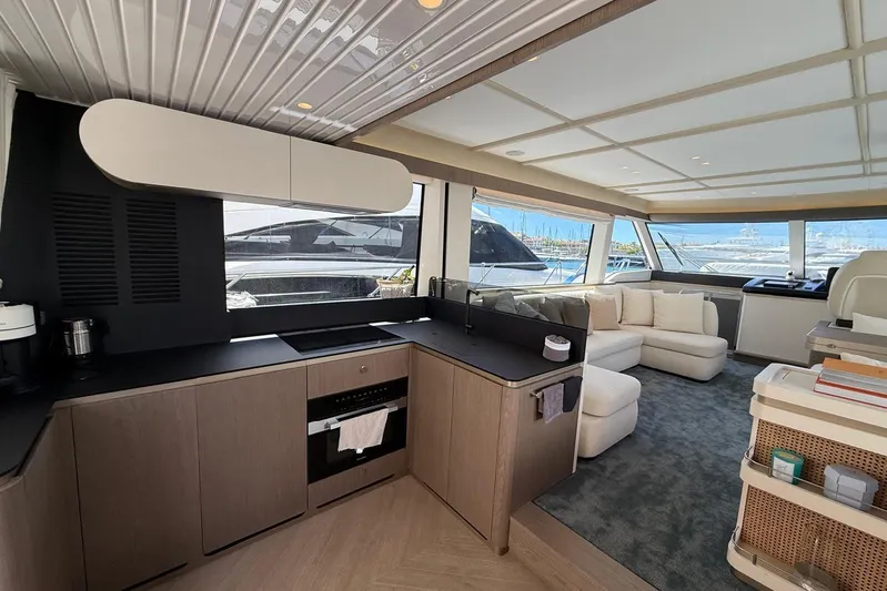 Dolce Far Niente Yacht Photos Pics Luxurious interior of 2024 Azimut Magellano 60 yacht with modern kitchen and spacious seating area.