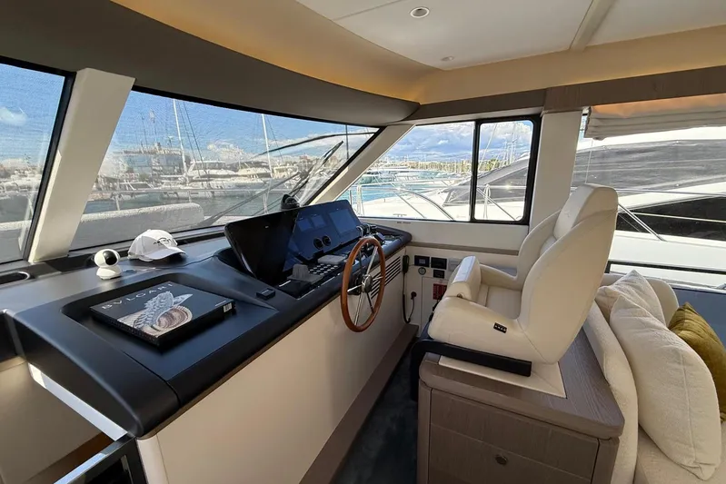 Dolce Far Niente Yacht Photos Pics Luxurious interior of 2024 Azimut Magellano 60 yacht with modern helm and plush seating.