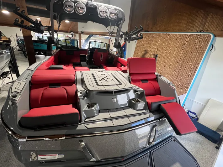 Yacht Photos Pics 2025 MasterCraft X24 boat with red seating and sleek design in showroom.