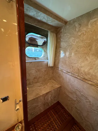 Yacht Photos Pics Luxurious marble bathroom interior on a 2003 Astondoa 82 yacht with porthole window.