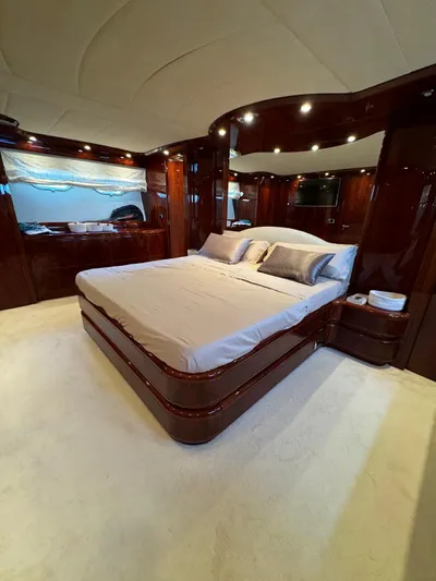  Yacht Photos Pics Luxurious bedroom interior of a 2003 Astondoa 82 yacht with elegant wood finishes.
