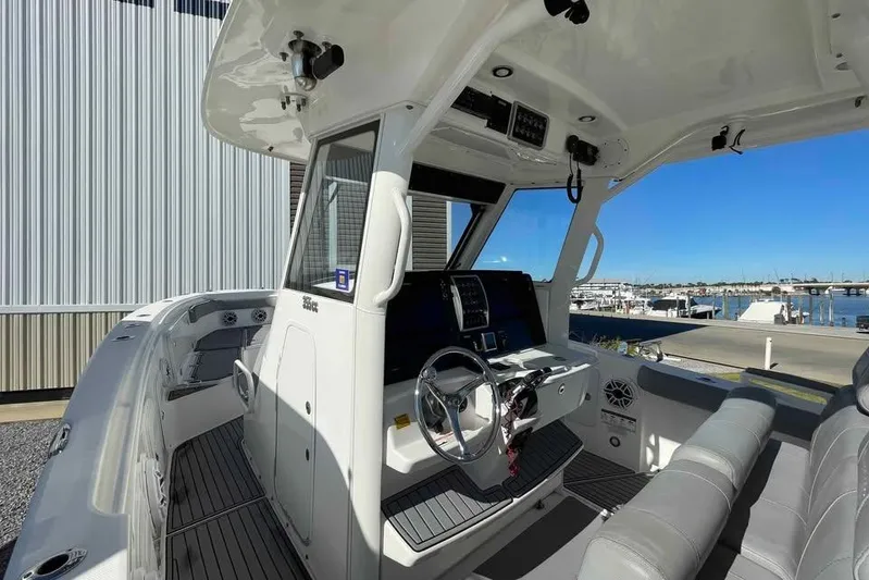 Outta Line Yacht Photos Pics 2013 Everglades 355 Center Console boat interior with steering wheel and seating.