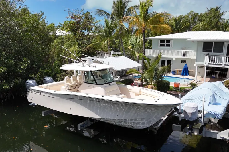  Yacht Photos Pics 2021 Grady-White Canyon 336 boat docked near tropical home with pool.