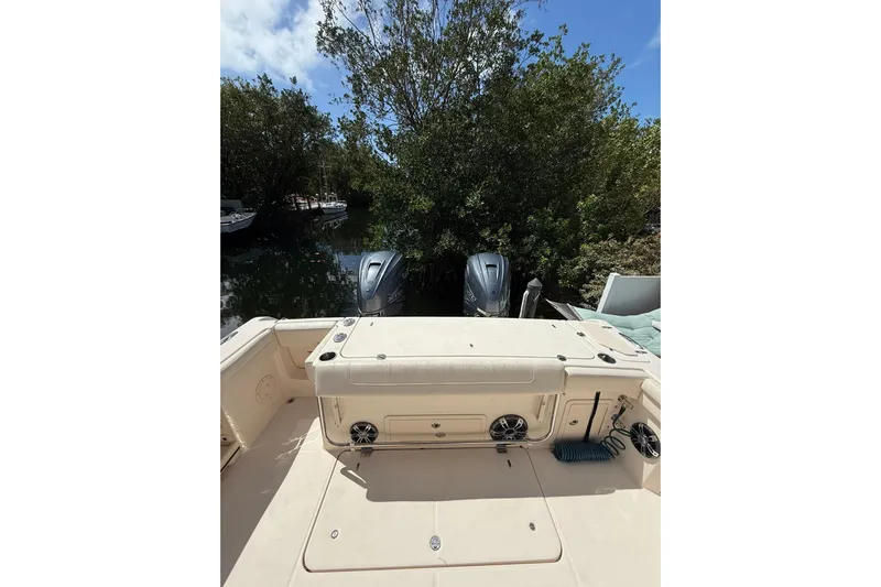  Yacht Photos Pics 2021 Grady-White Canyon 336 boat with dual engines, docked near lush greenery.