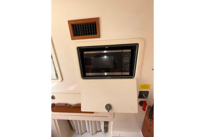  Yacht Photos Pics 2021 Grady-White Canyon 336 interior with built-in microwave and control panel.