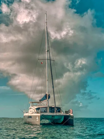 Jubilee Yacht Photos Pics Sailing catamaran Leopard 48, 2015 model, on calm sea under dramatic cloudy sky.