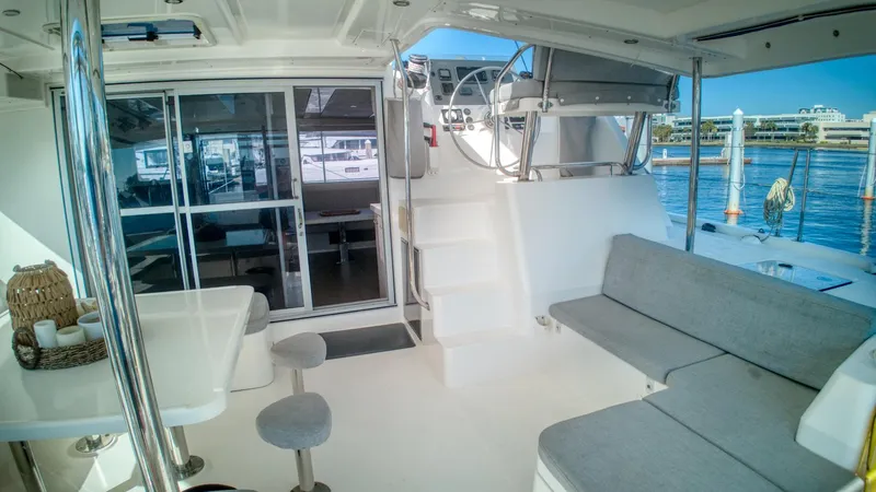 Jubilee Yacht Photos Pics Luxurious Leopard 48 yacht interior with seating, table, and helm, docked at marina.