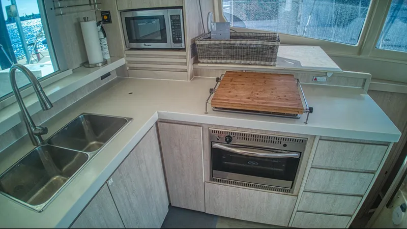 Jubilee Yacht Photos Pics Modern kitchen in a 2015 Leopard 48 yacht with sink, microwave, and oven.