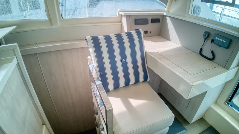 Jubilee Yacht Photos Pics Interior of 2015 Leopard 48 yacht with striped cushion on a beige seat.