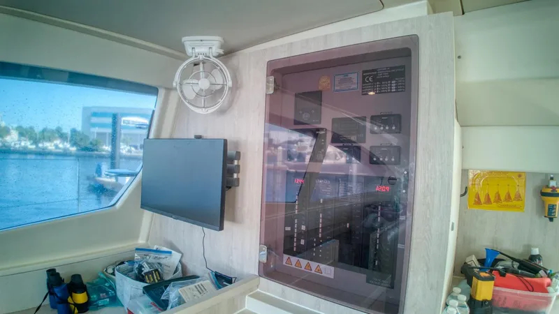 Jubilee Yacht Photos Pics Control panel inside a 2015 Leopard 48 catamaran, featuring a fan and a mounted screen.