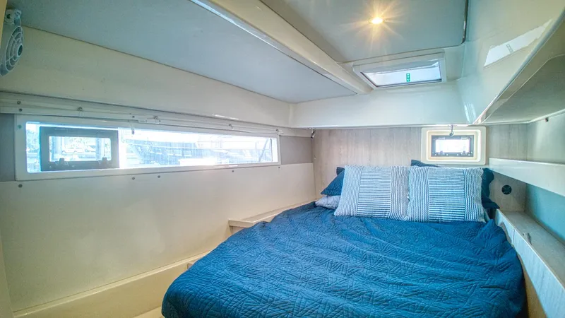 Jubilee Yacht Photos Pics Cozy bedroom in 2015 Leopard 48 yacht with blue bedding and ample natural light.