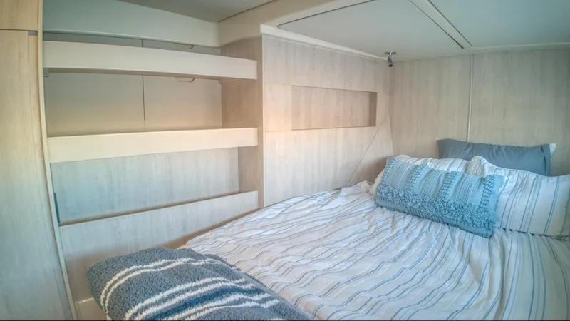 Jubilee Yacht Photos Pics Cozy bedroom in 2015 Leopard 48 yacht with striped bedding and modern design.