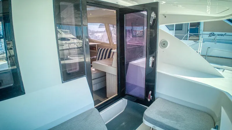 Jubilee Yacht Photos Pics Leopard 48 yacht interior view, featuring open glass doors and striped seating, 2015 model.