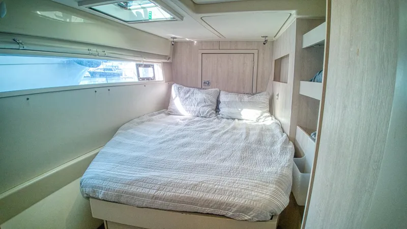 Jubilee Yacht Photos Pics Cozy bedroom interior in a 2015 Leopard 48 yacht with natural light and modern design.