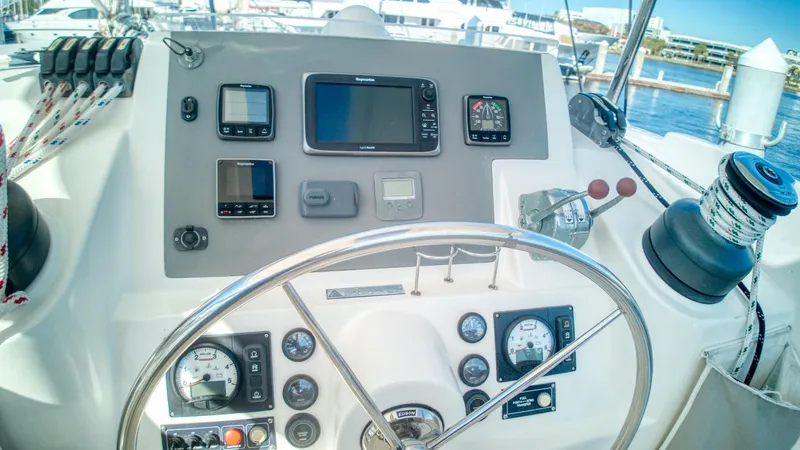 Jubilee Yacht Photos Pics Leopard 48 yacht helm with navigation instruments, steering wheel, and marina view.