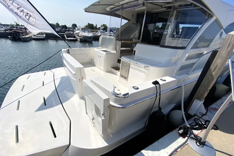  Yacht Photos Pics 2025 Riviera 465 SUV yacht docked at marina, showcasing spacious deck and modern design.