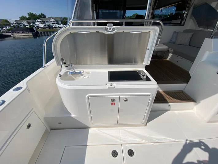  Yacht Photos Pics Outdoor kitchenette on 2025 Riviera 465 SUV yacht, featuring sink and stove.