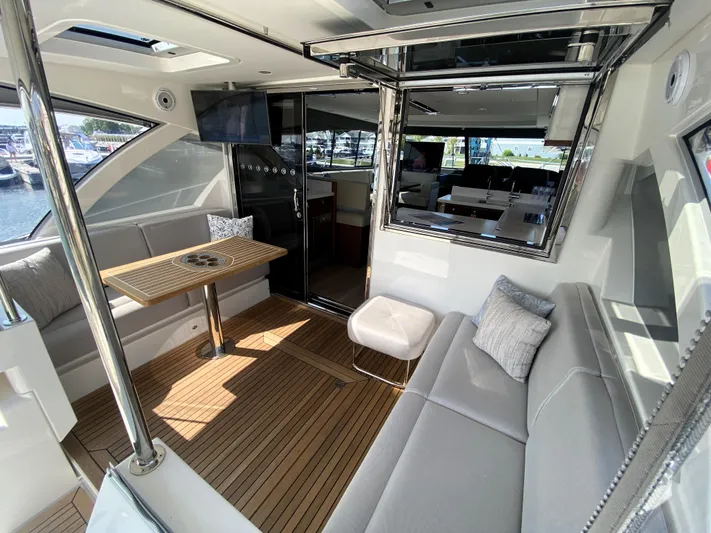  Yacht Photos Pics Luxurious interior of 2025 Riviera 465 SUV yacht with elegant seating and wooden flooring.