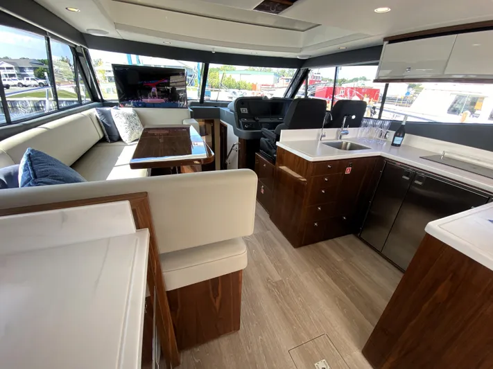  Yacht Photos Pics Luxurious interior of 2025 Riviera 465 SUV yacht with modern kitchen and seating area.