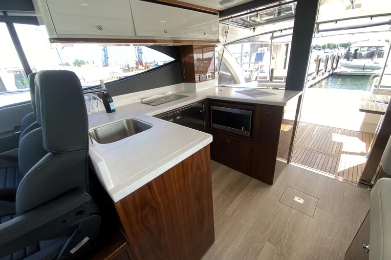  Yacht Photos Pics Luxurious interior of 2025 Riviera 465 SUV yacht with modern kitchen and sleek design.