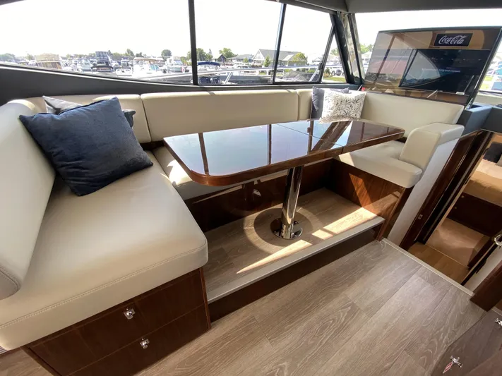  Yacht Photos Pics Luxurious interior of 2025 Riviera 465 SUV with elegant seating and polished table.