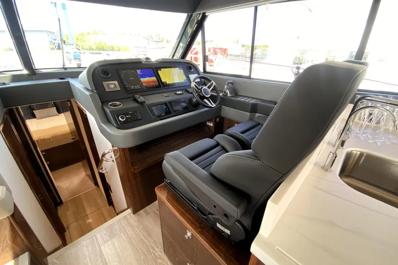  Yacht Photos Pics 2025 Riviera 465 SUV helm with modern controls and luxurious seating.