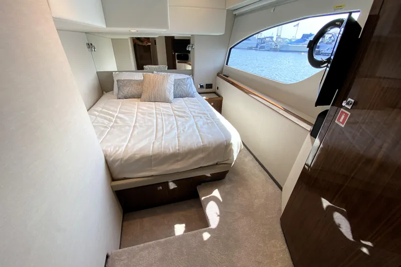  Yacht Photos Pics Luxurious bedroom interior of 2025 Riviera 465 SUV yacht with waterfront view.