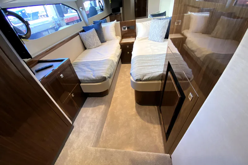  Yacht Photos Pics Luxurious interior of 2025 Riviera 465 SUV yacht with twin beds and elegant wood finish.