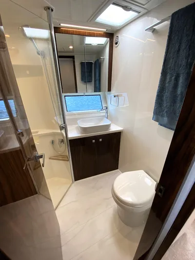  Yacht Photos Pics Modern bathroom in 2025 Riviera 465 SUV yacht with sleek design and ocean view.