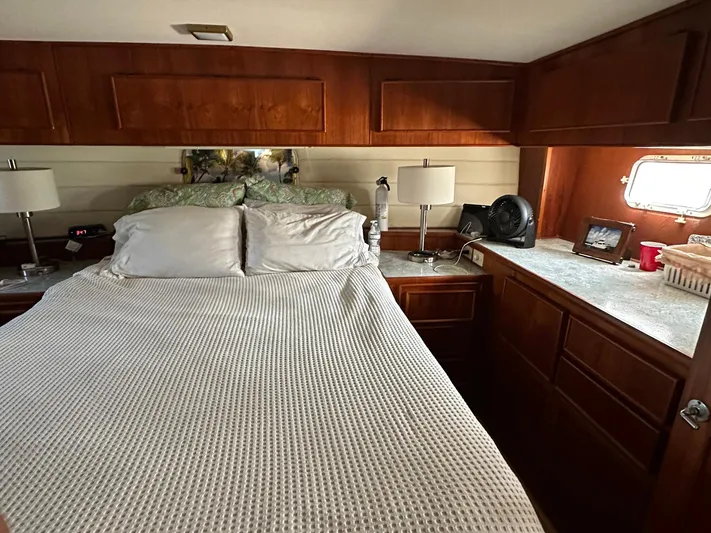 Luv'n Life Yacht Photos Pics Cozy bedroom interior of 1989 Atlantic 47 Motor Yacht with wooden cabinetry and soft lighting.