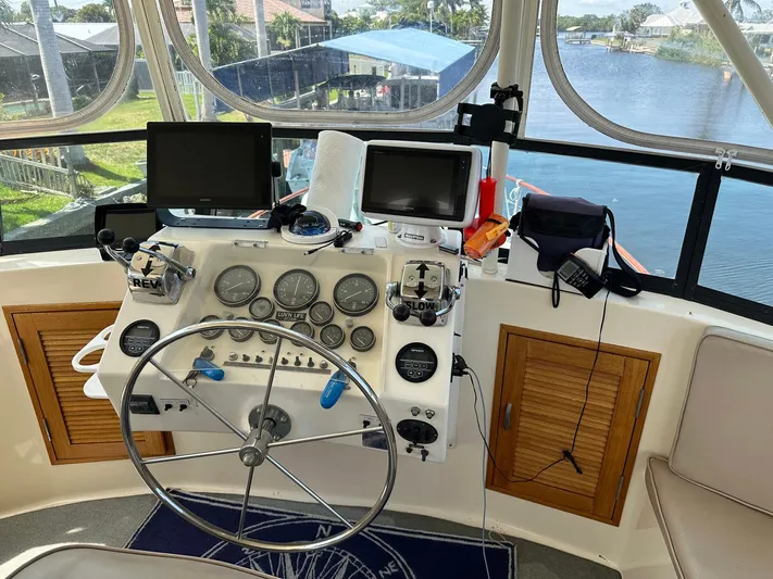 Luv'n Life Yacht Photos Pics 1989 Atlantic 47 Motor Yacht helm with navigation equipment and scenic waterway view.