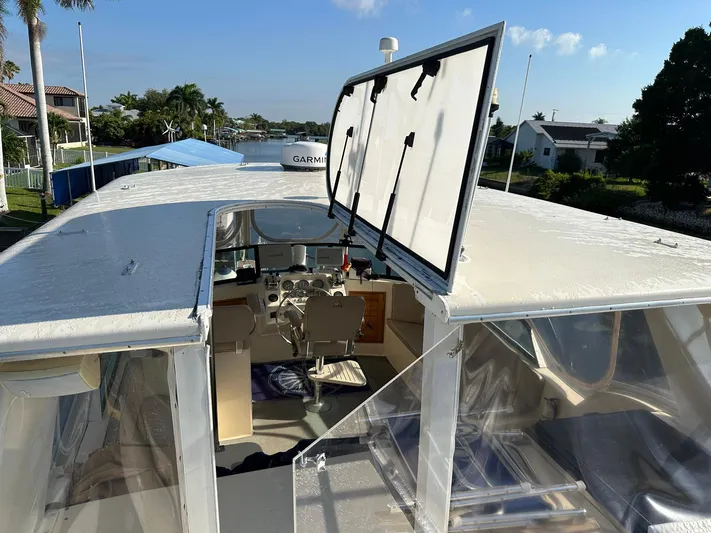 Luv'n Life Yacht Photos Pics 1989 Atlantic 47 Motor Yacht cockpit with open hatch, docked near waterfront homes.