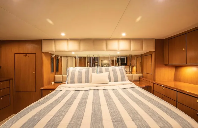  Yacht Photos Pics Luxurious bedroom interior of 1999 Ocean Yachts 60 Convertible with striped bedding.