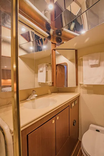  Yacht Photos Pics Luxurious bathroom in 1999 Ocean Yachts 60 Convertible, featuring elegant wood cabinetry and modern fixtures.