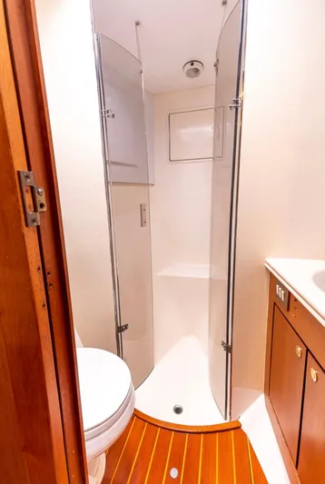  Yacht Photos Pics 1999 Ocean Yachts 60 Convertible bathroom with shower, wooden flooring, and modern fixtures.