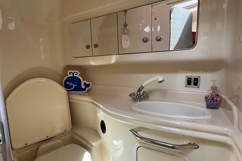  Yacht Photos Pics 2005 Sea Ray 340 Sundancer bathroom with sink, mirror, and storage cabinets.