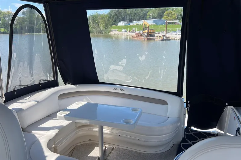 Yacht Photos Pics 2005 Sea Ray 340 Sundancer interior with seating and table, overlooking a serene waterfront.