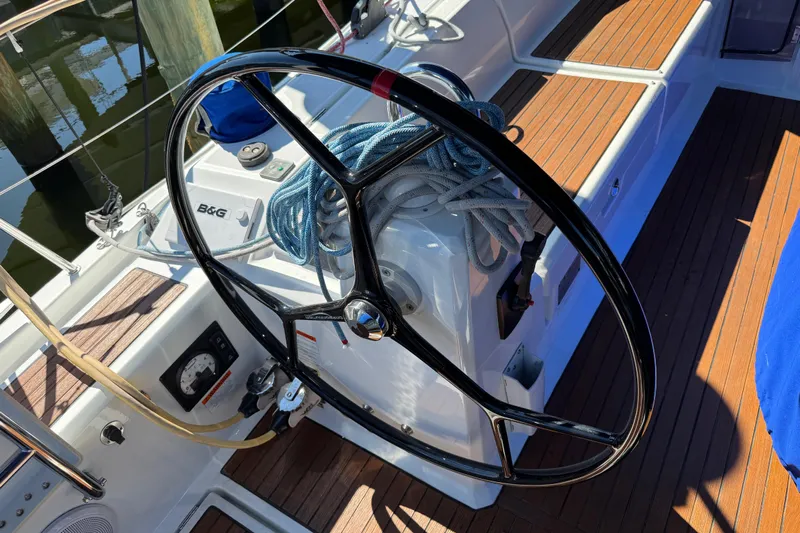 Take 2 Yacht Photos Pics Steering wheel of 2019 Beneteau Oceanis 41.1 sailboat with coiled ropes on deck.