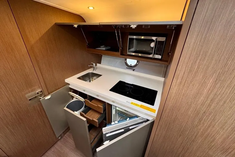  Yacht Photos Pics Compact kitchen in 2021 Beneteau Gran Turismo 40 yacht with modern appliances and storage.