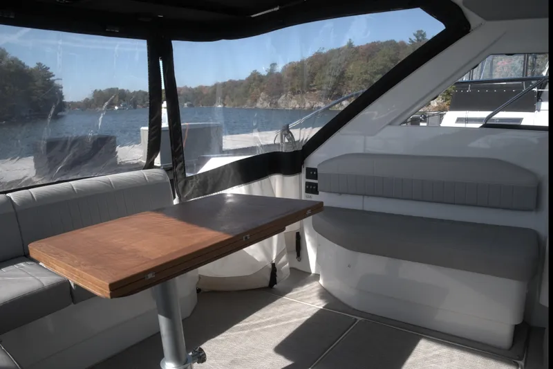  Yacht Photos Pics Interior of 2021 Beneteau Gran Turismo 40 yacht with seating and table, overlooking water.
