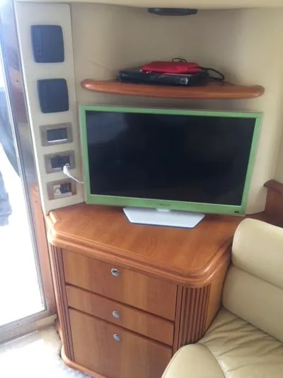  Yacht Photos Pics Interior of 2005 Azimut 43 yacht with TV, wooden cabinet, and beige seating.