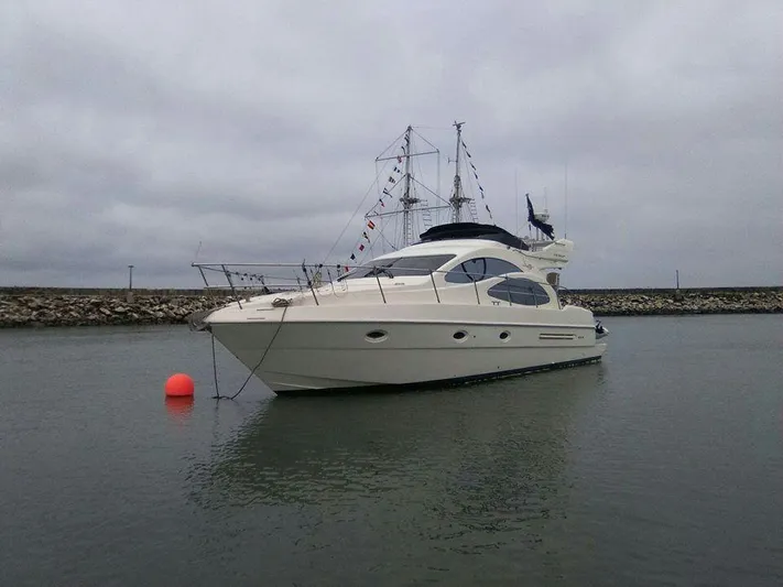  Yacht Photos Pics 2005 Azimut 43 yacht anchored in calm waters under cloudy skies.