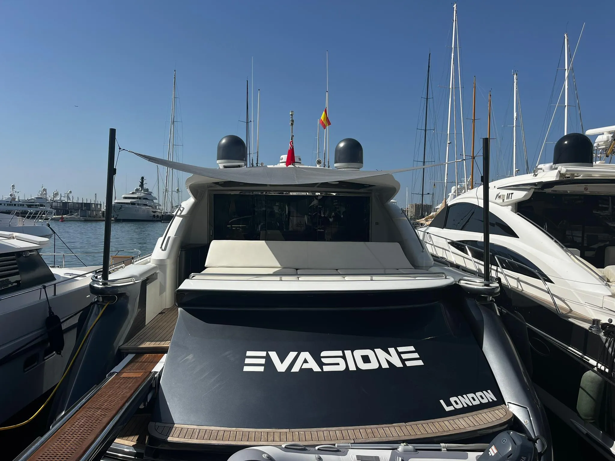2004 Pershing 76 yacht docked in marina, rear view with "Evasione" branding.