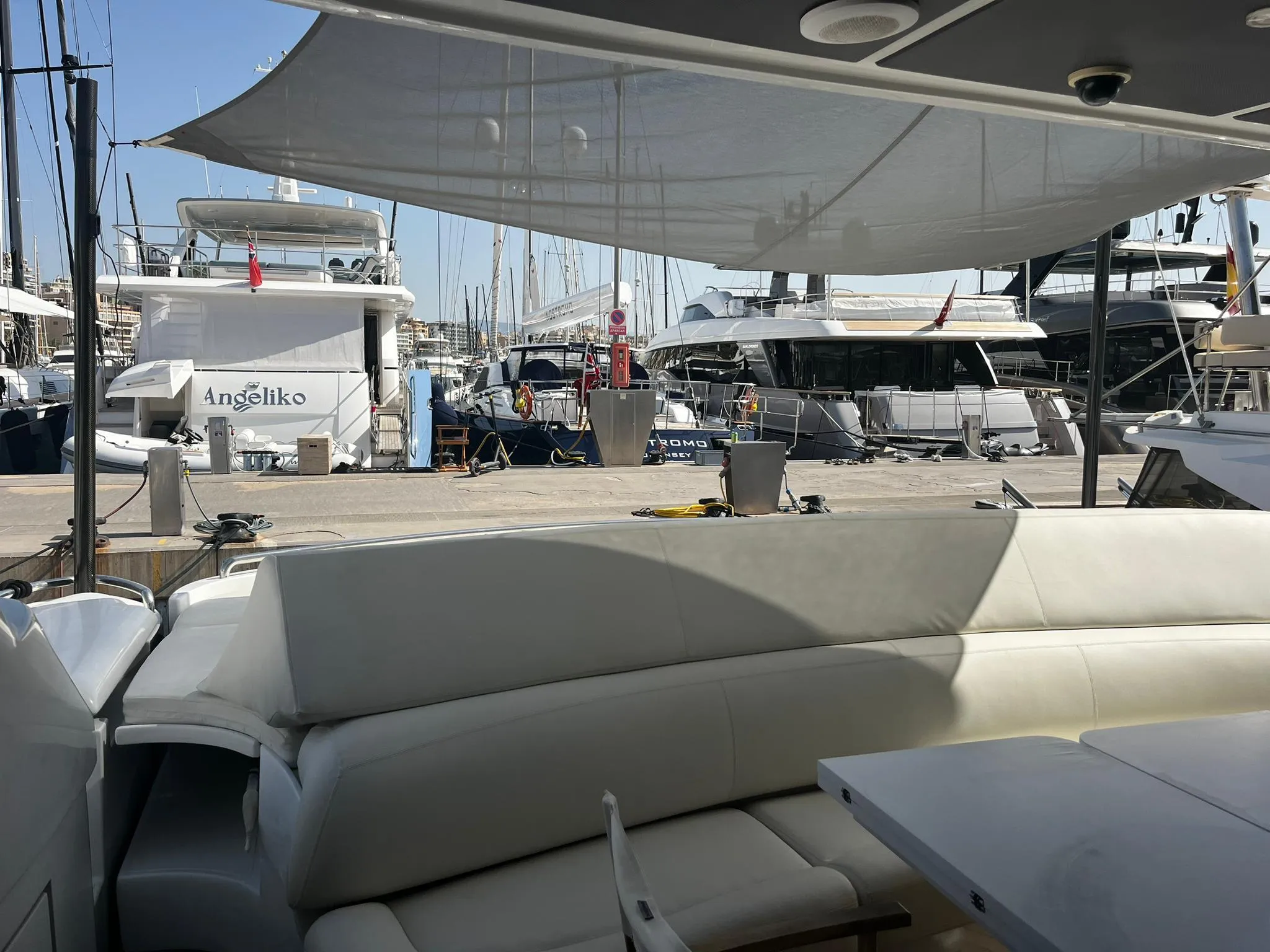 Luxurious 2004 Pershing 76 yacht interior with marina view, featuring elegant white seating.